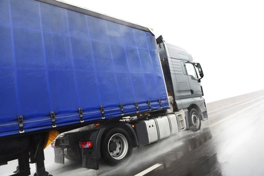 Blue lorry driving on wet road  - GettyImages-183198007.jpg